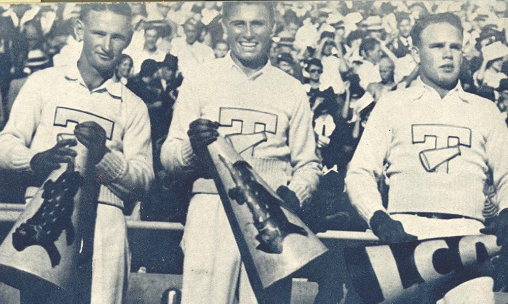 Three 1934 TCU male Yell Leaders smile holding megaphones